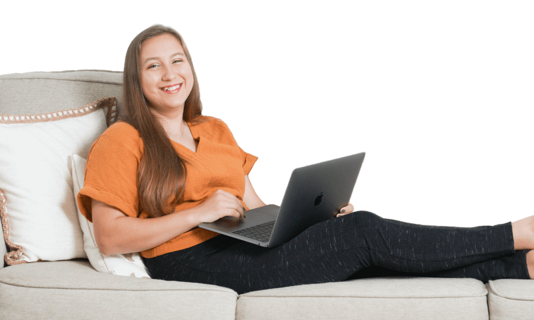 Valeriya Zaytseva sitting on a couch, smiling at the viewer, and holding her laptop in her lap.